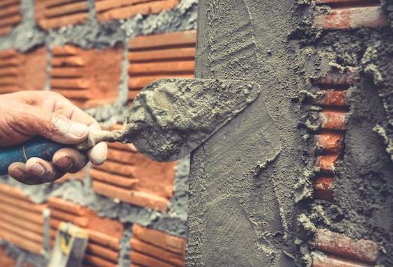 Trowel spreading protective coating over brickwork